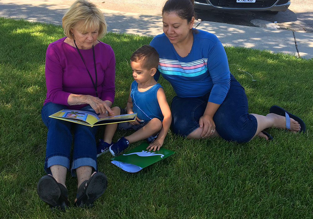 Kids reading in lawn to work on summer learning