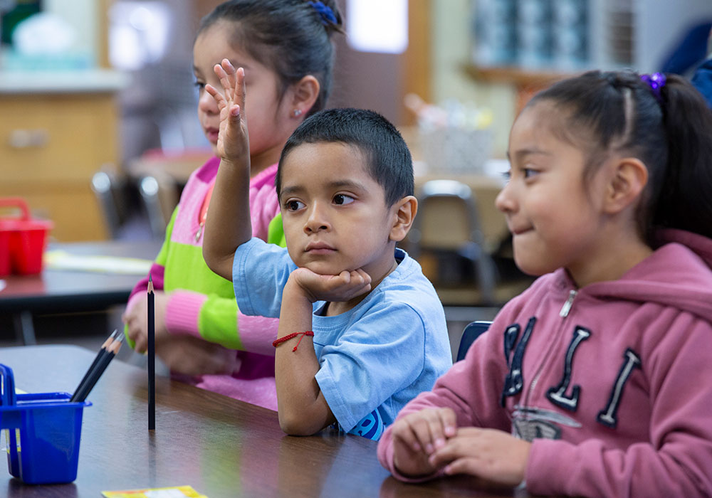 kid raising hand at summer learning program