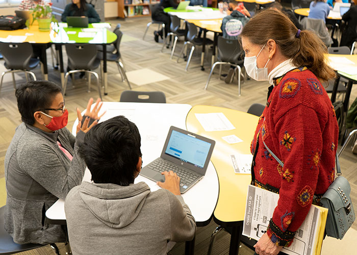 Volunteer assists family sitting at table with FAFSA