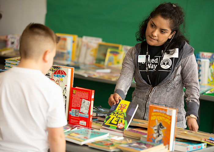 Volunteer shows book to kid