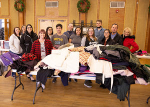 Greystar staff pose by the coats they donated to Lincoln Elementary, Mill Creek Elementary, and more