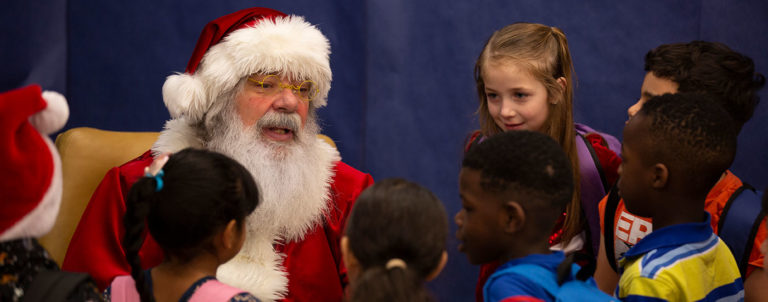 Santa talking to a group of kids at Moss Elementary