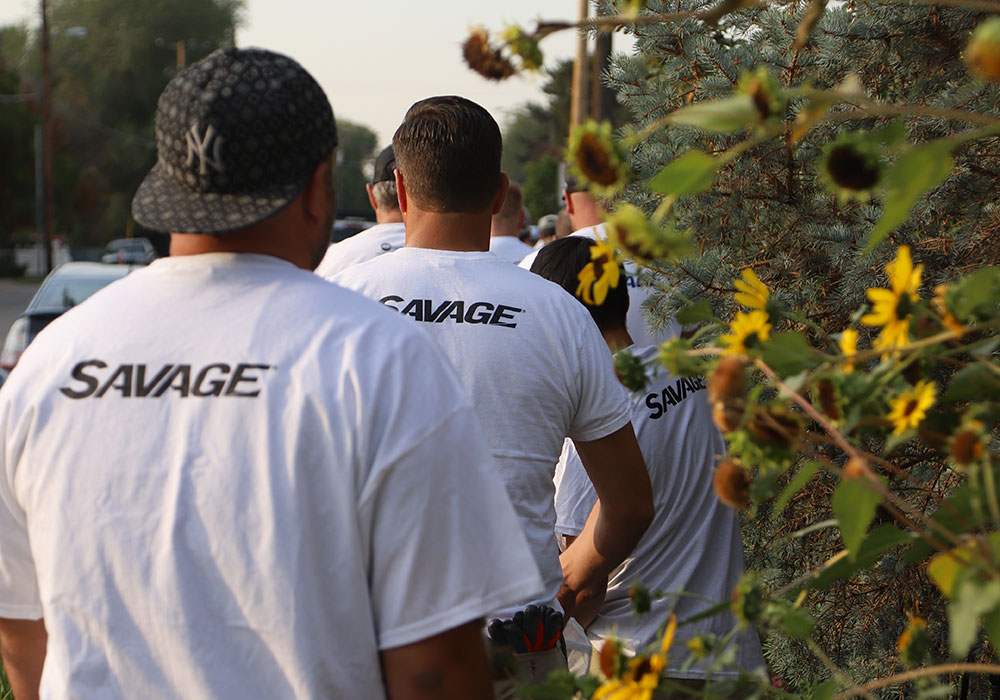 Volunteers from Savage walk by sunflowers at Monarch Park