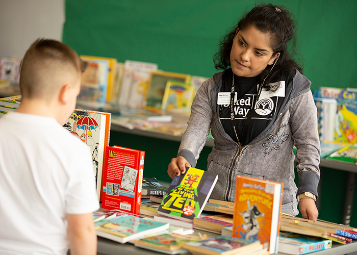 United Way of Salt Lake volunteer holds up book option for kid