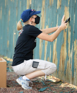 Person volunteering to paint fence
