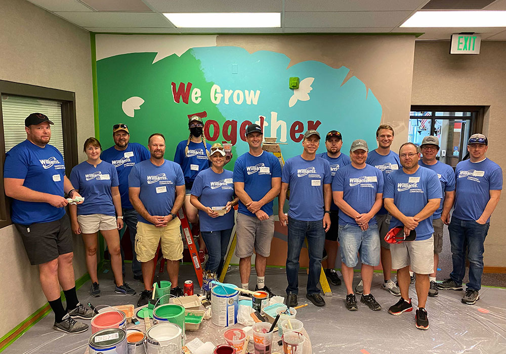 Williams Volunteers Stand in front of painting they did for Day of Caring