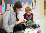 Volunteer reading with student at Read Across America Day